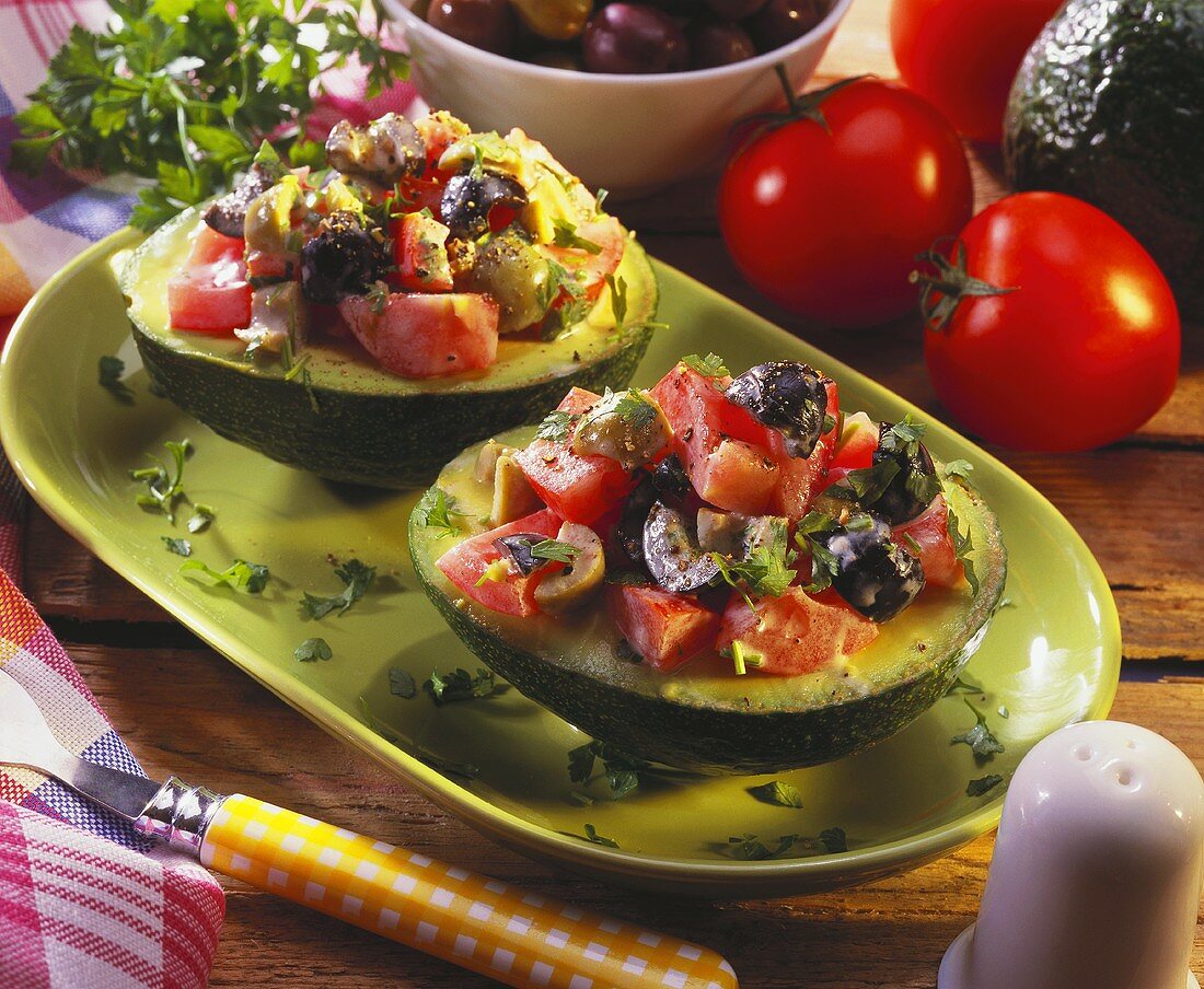 Avocado salad with tomatoes and olives in avocado halves