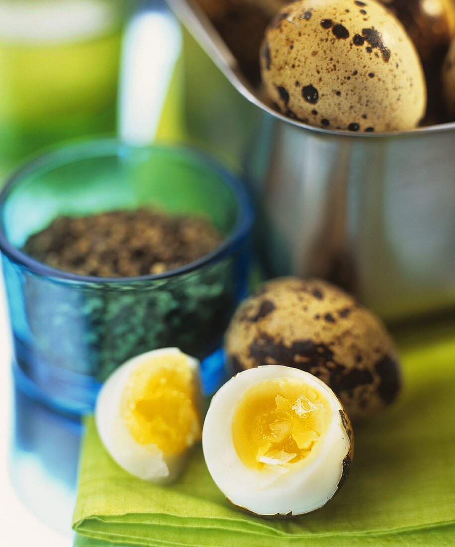 Boiled quail's eggs, one halved in foreground