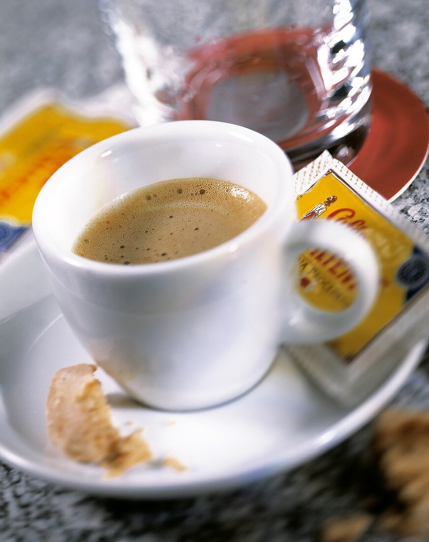 Expresso with sugar sachet & biscuit with bite taken