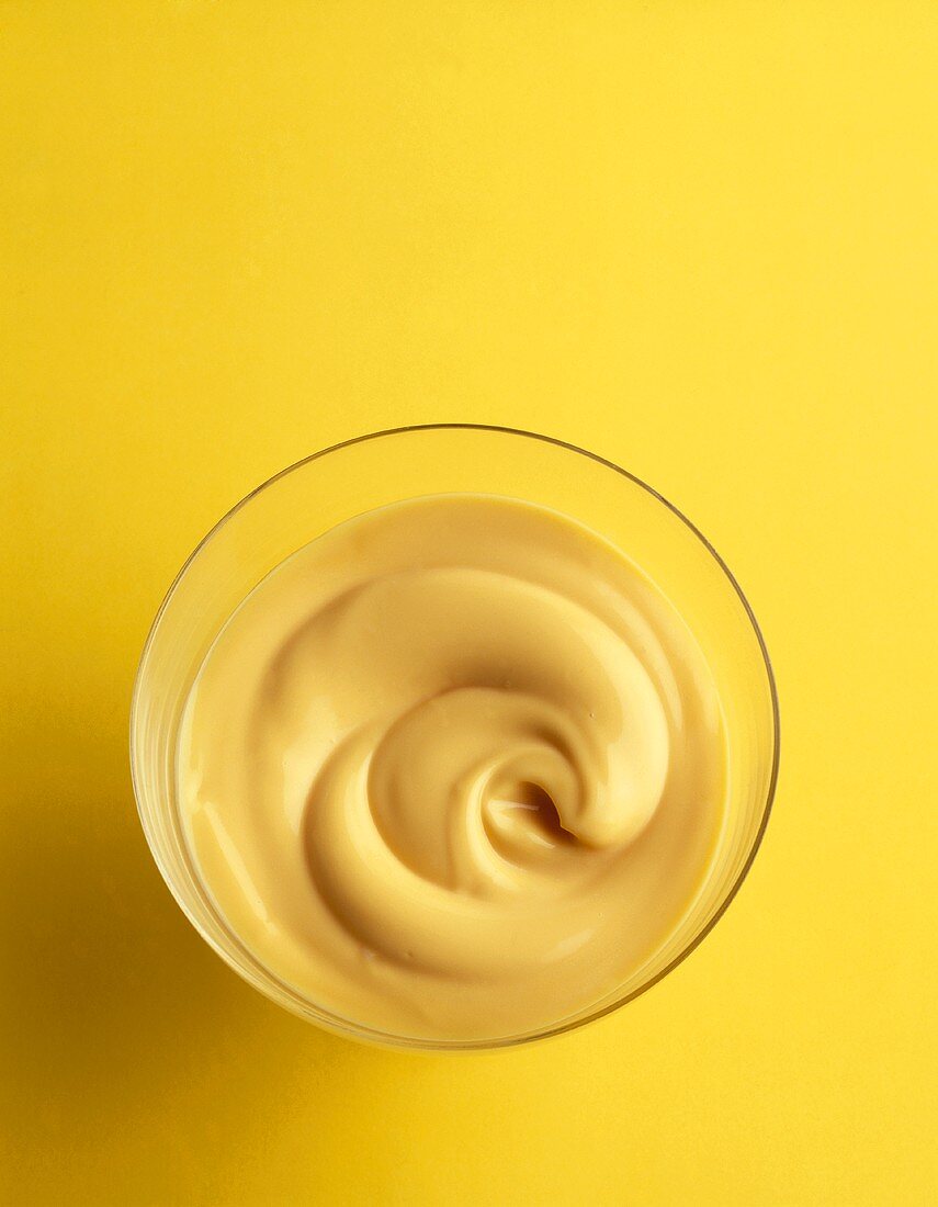 Vanillecreme in einem Glas mit gelbem Hintergrund