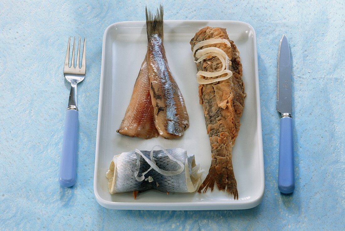 Rollmops, matjes herring fillet and fried herring on plate