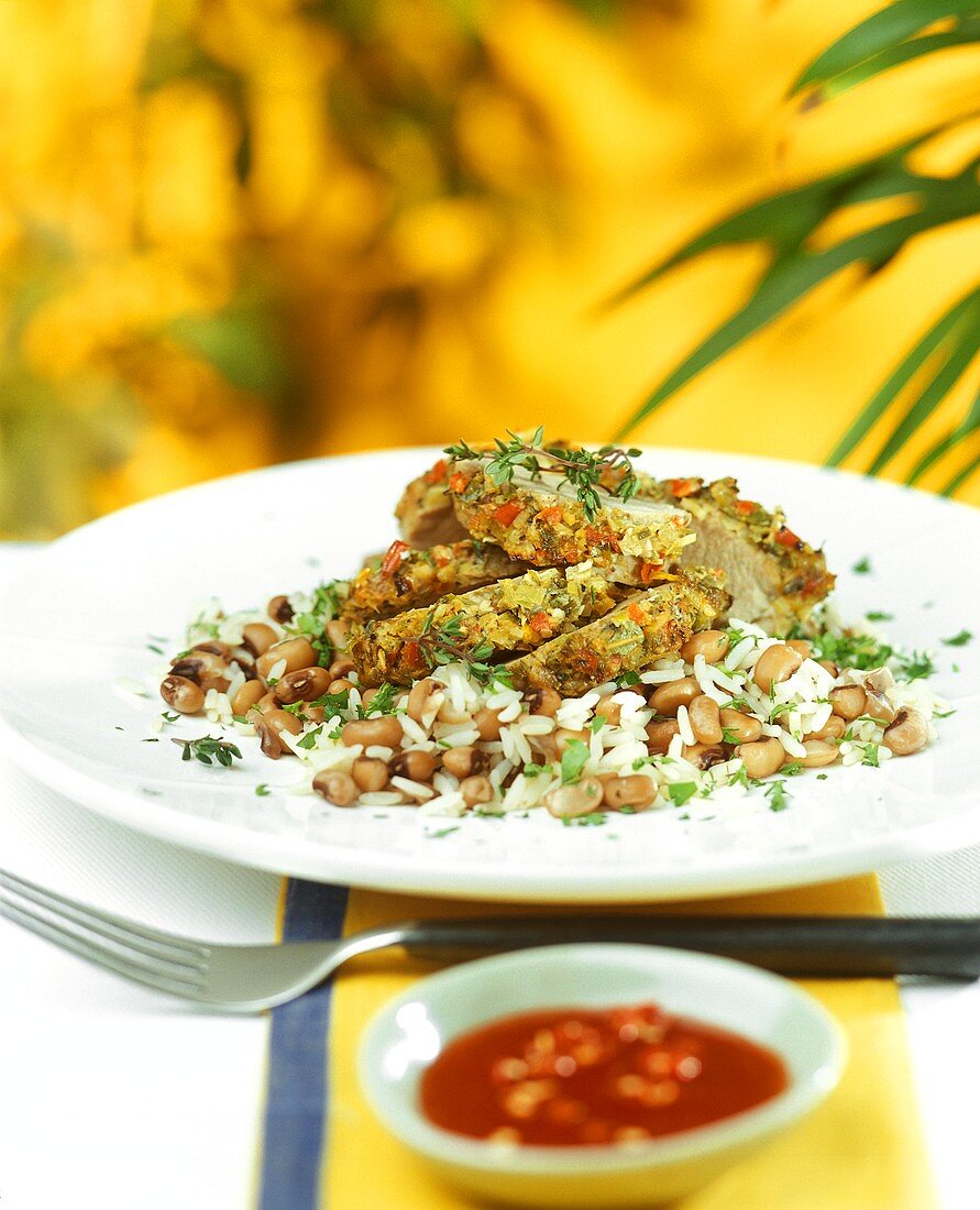 Pork fillet with vegetable crust on rice and beans