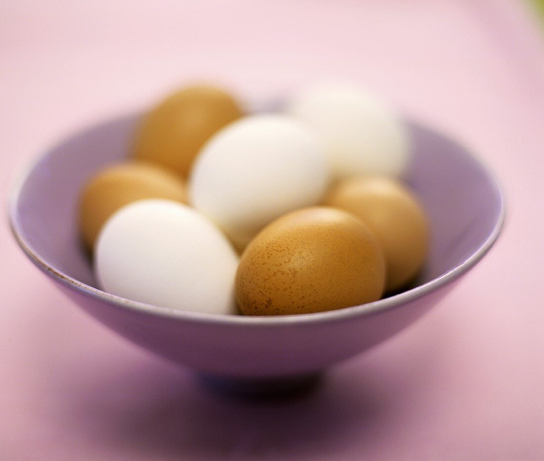 Brown and white eggs in a bowl