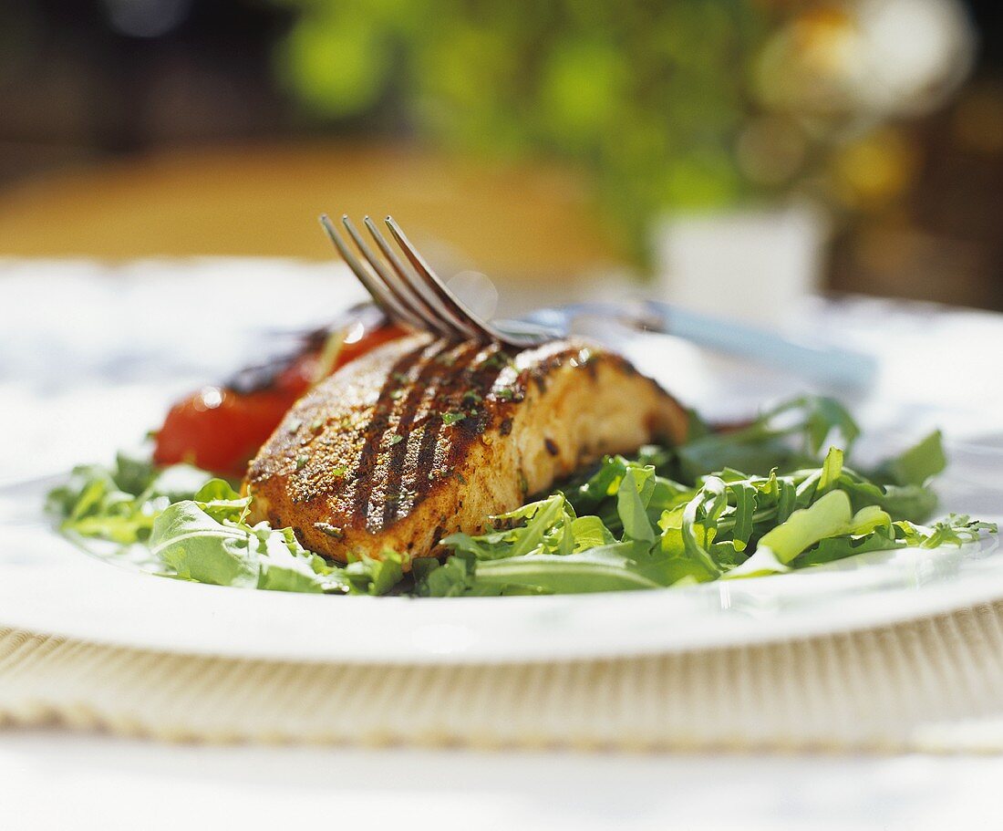 Grilled salmon steak on rocket