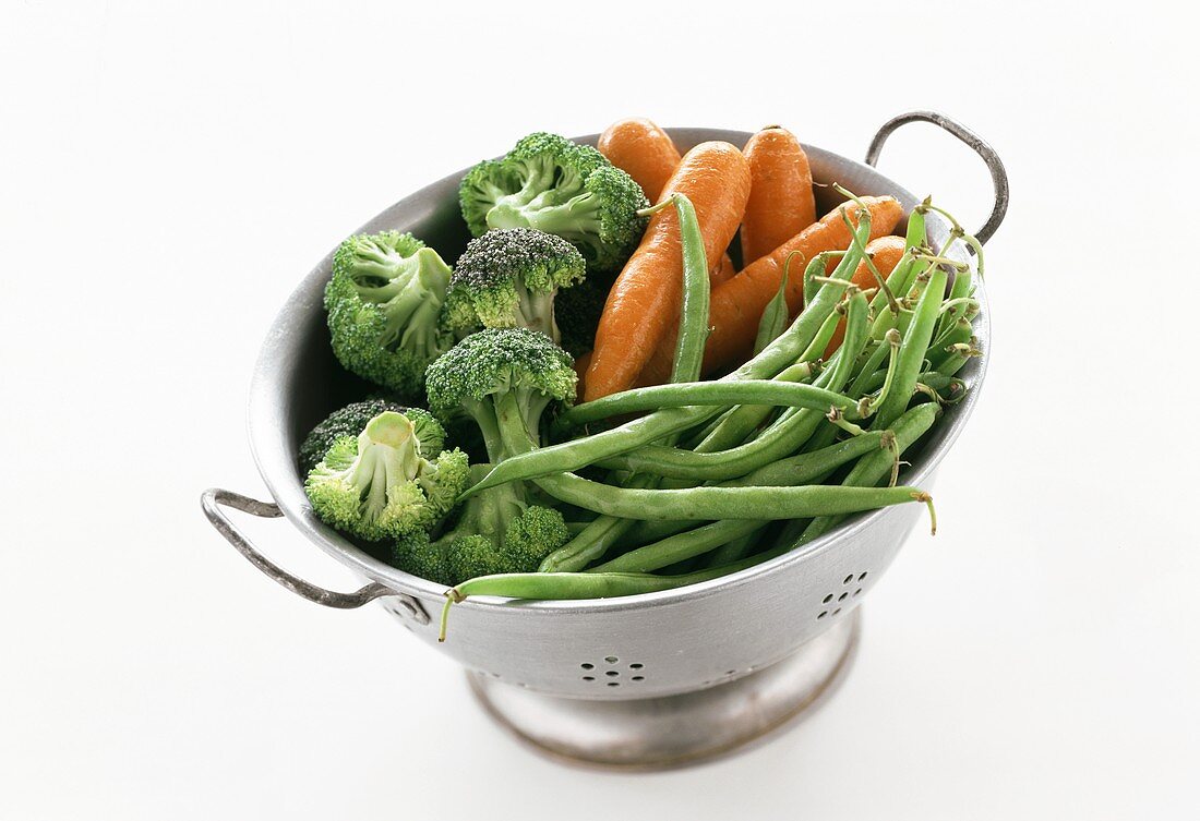 Beans, carrots and broccoli in a metal strainer