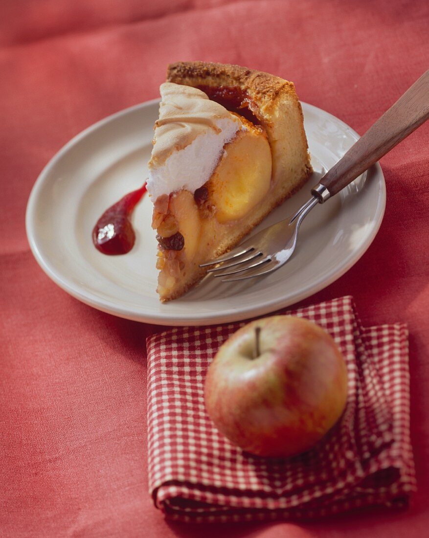 A piece of baked apple cake with meringue topping