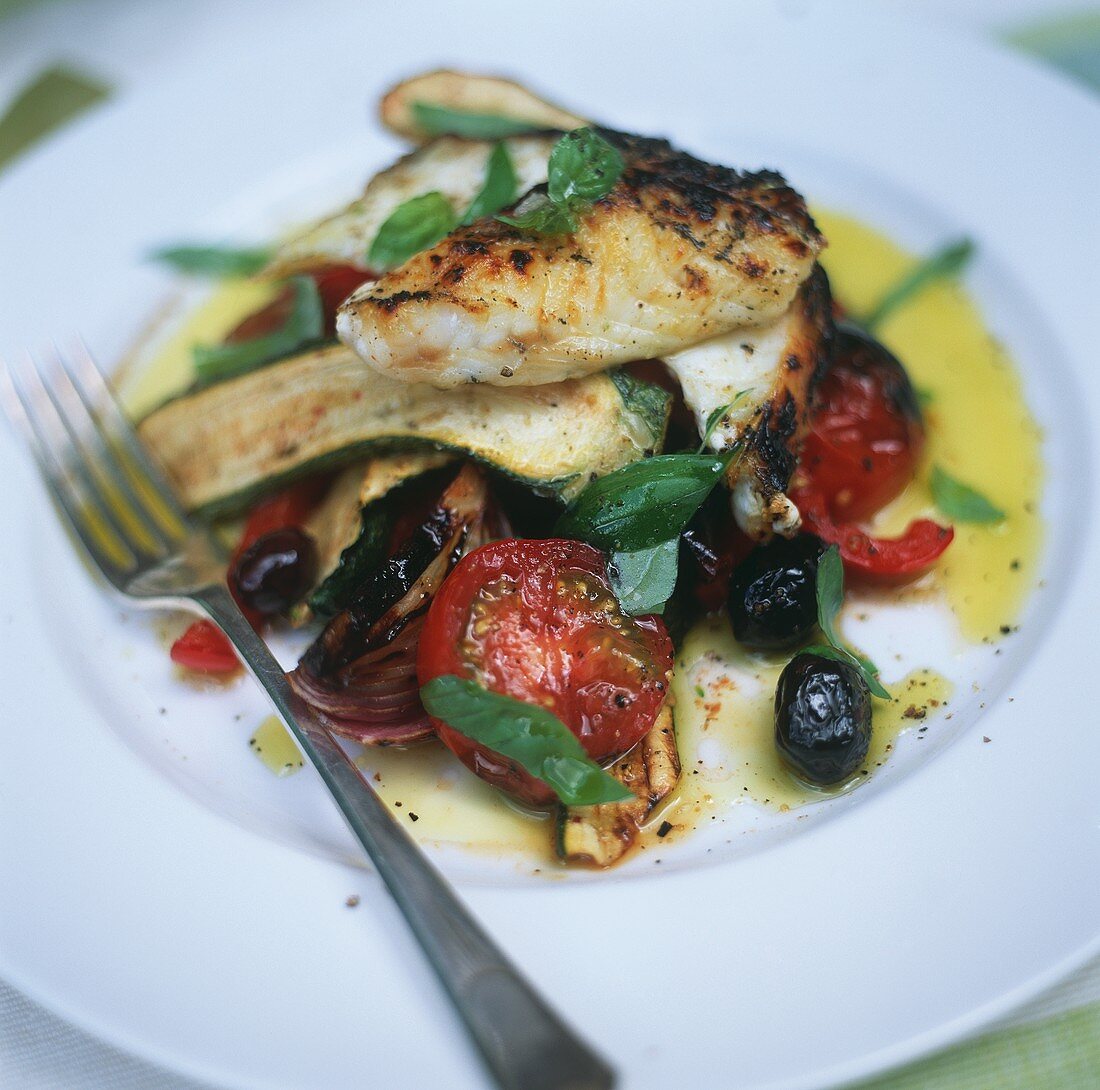 Oven-baked fish fillet on summer vegetables