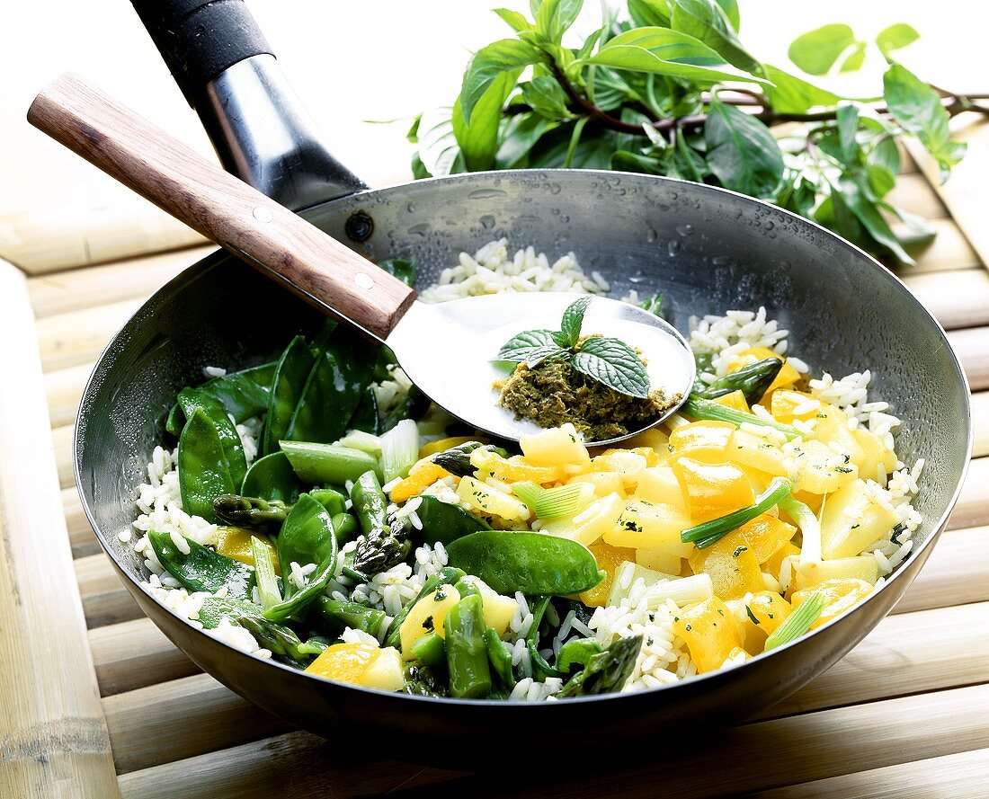 Reis-Gemüse-Wok & Löffel mit Zutaten für Thai-Curry-Sauce