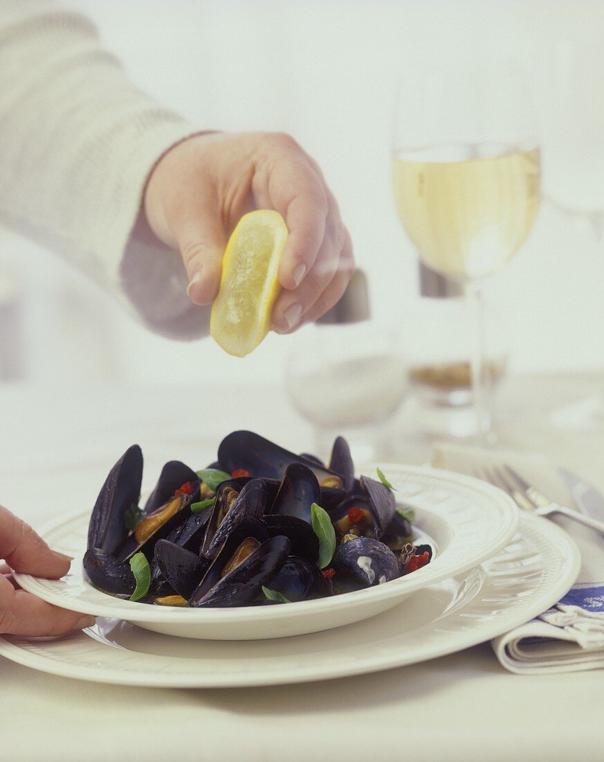 Gedämpfte Miesmuscheln mit Zitrone beträufeln