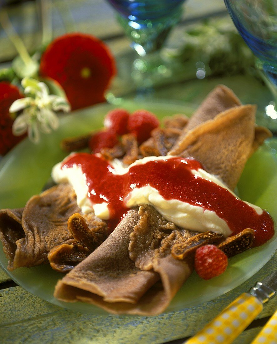 Chocolate pancakes with vanilla mousse and raspberry sauce