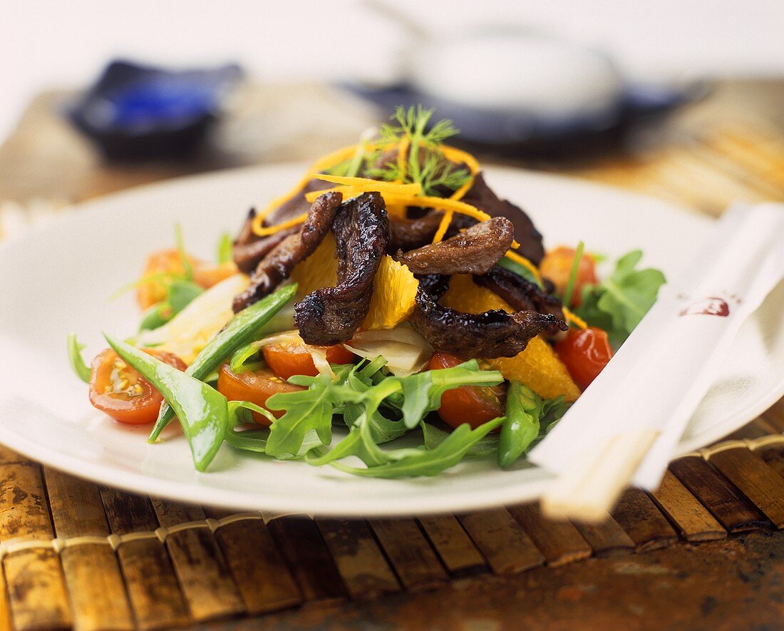 Rocket salad with strips of roast meat and oranges 