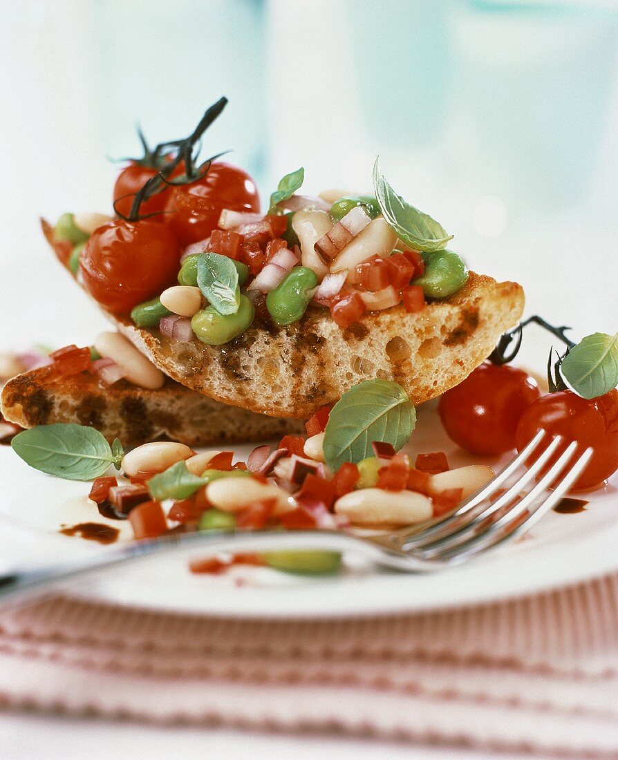 Toasted bread with bean salad and cocktail tomatoes