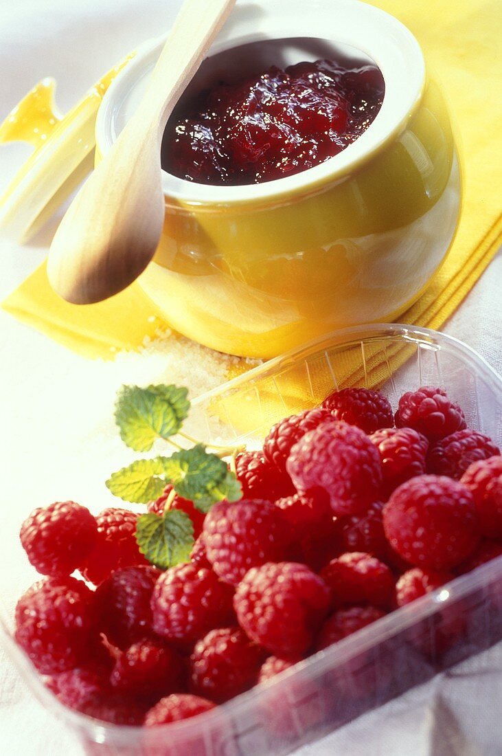 Raspberry jam and a dish of fresh raspberries
