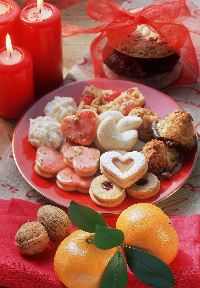 Colourful biscuit plate, décor: mandarins, walnuts, candles