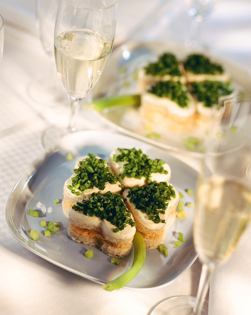 Open cheese & chive sandwiches arranged like 4-leaf clover