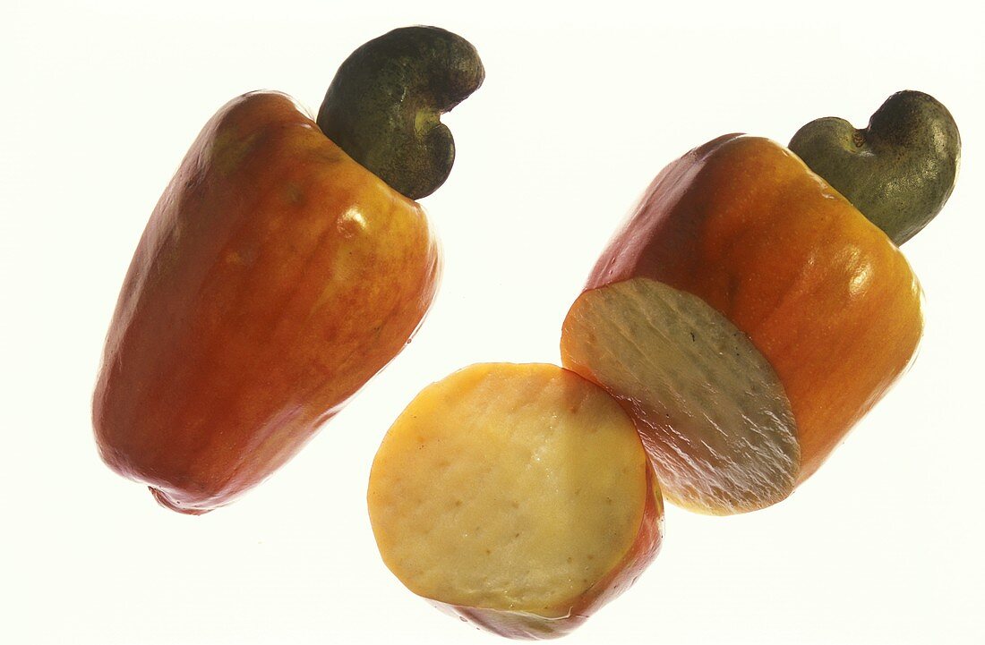 Zwei Cashewäpfel (mit -nüssen), einer davon aufgeschnitten