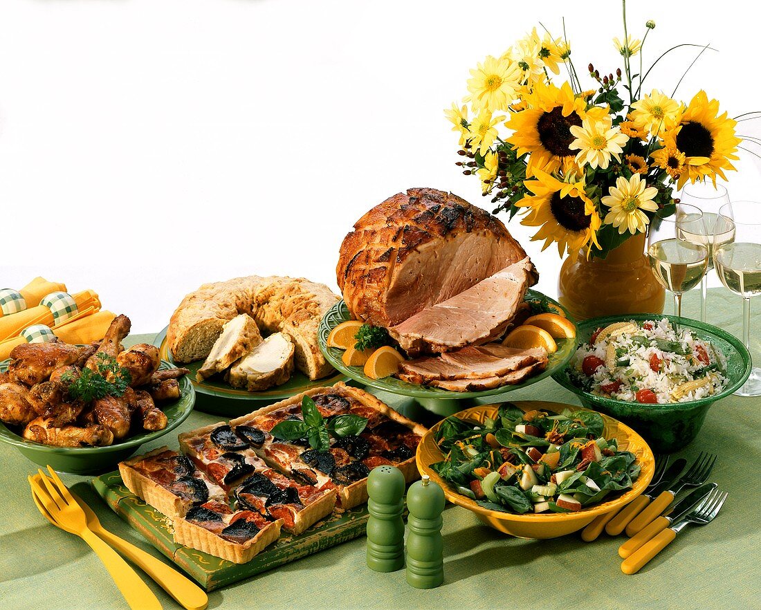 Party buffet with various dishes, flowers and wine