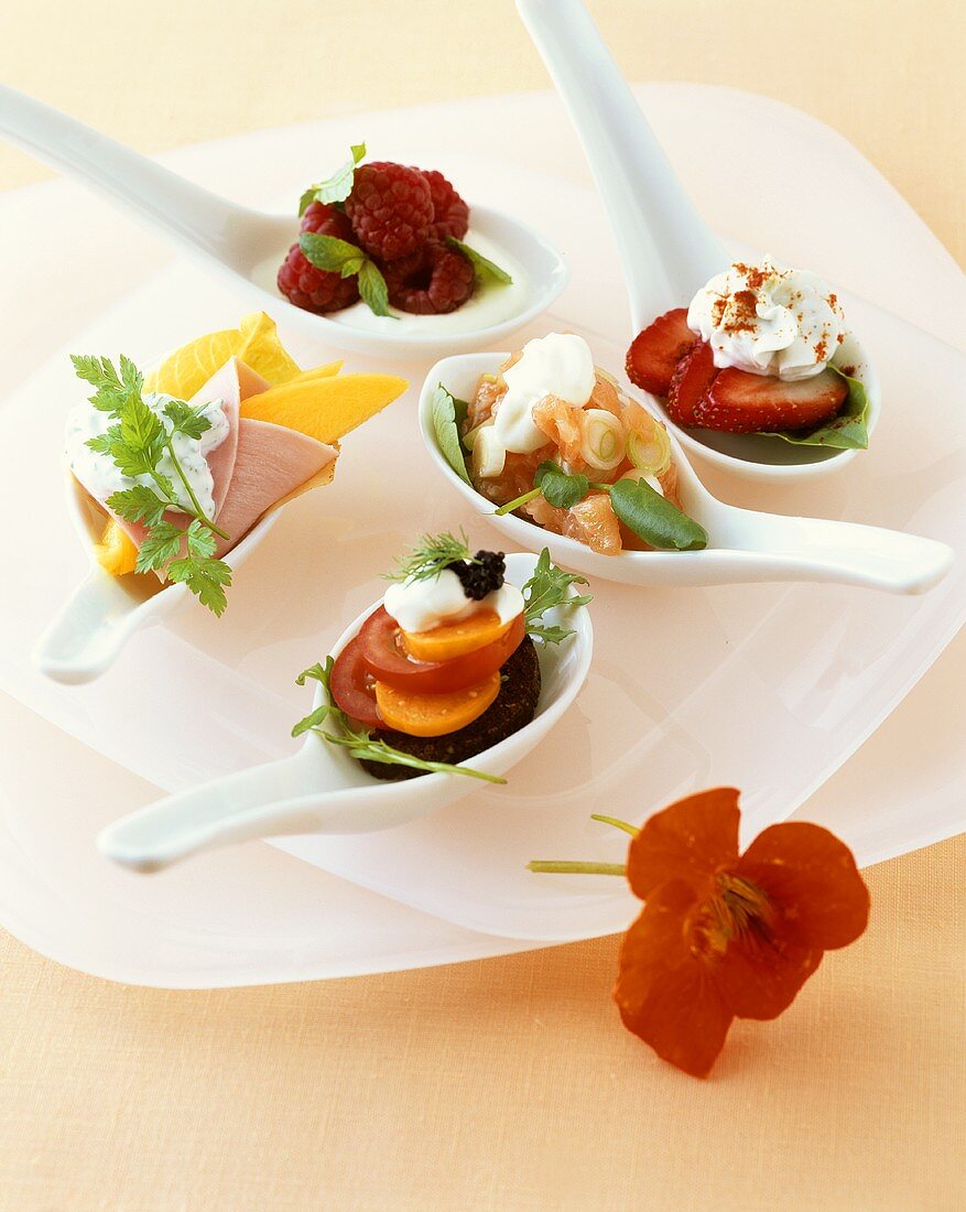 Assorted snacks served on china spoons