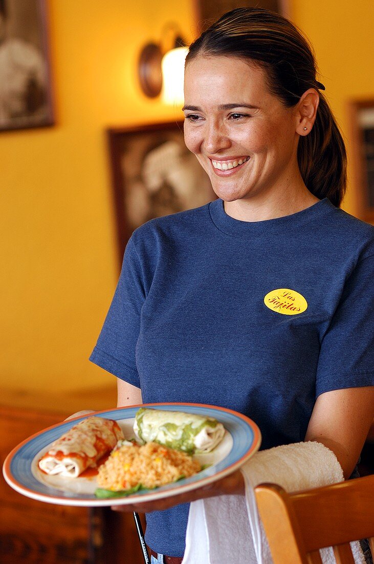 Junge Frau serviert Teller mit Enchiladas