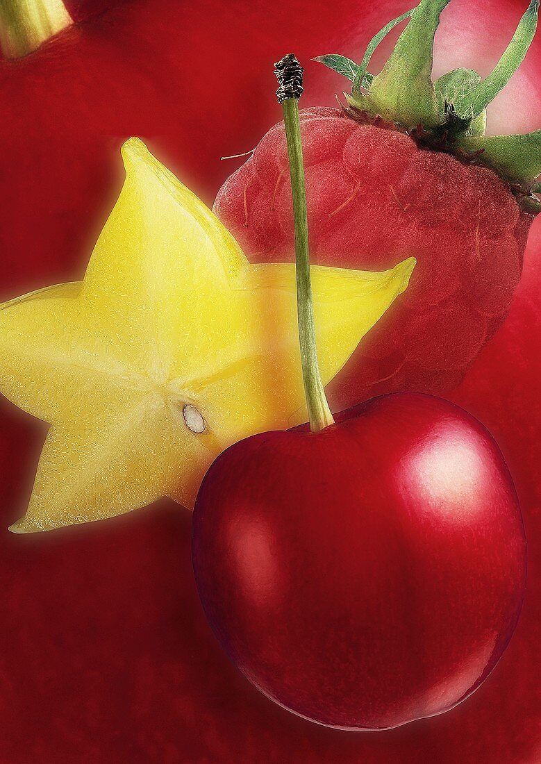 Artistic still life with cherry, carambola and raspberry