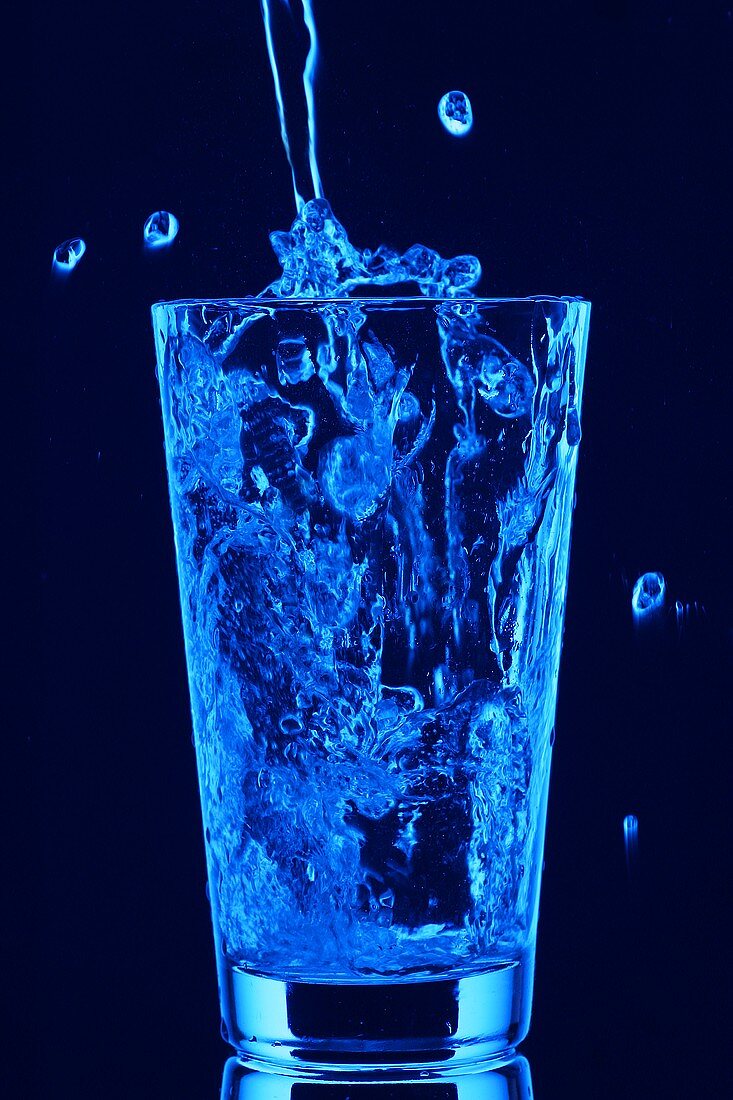 Blue water being poured into tumbler