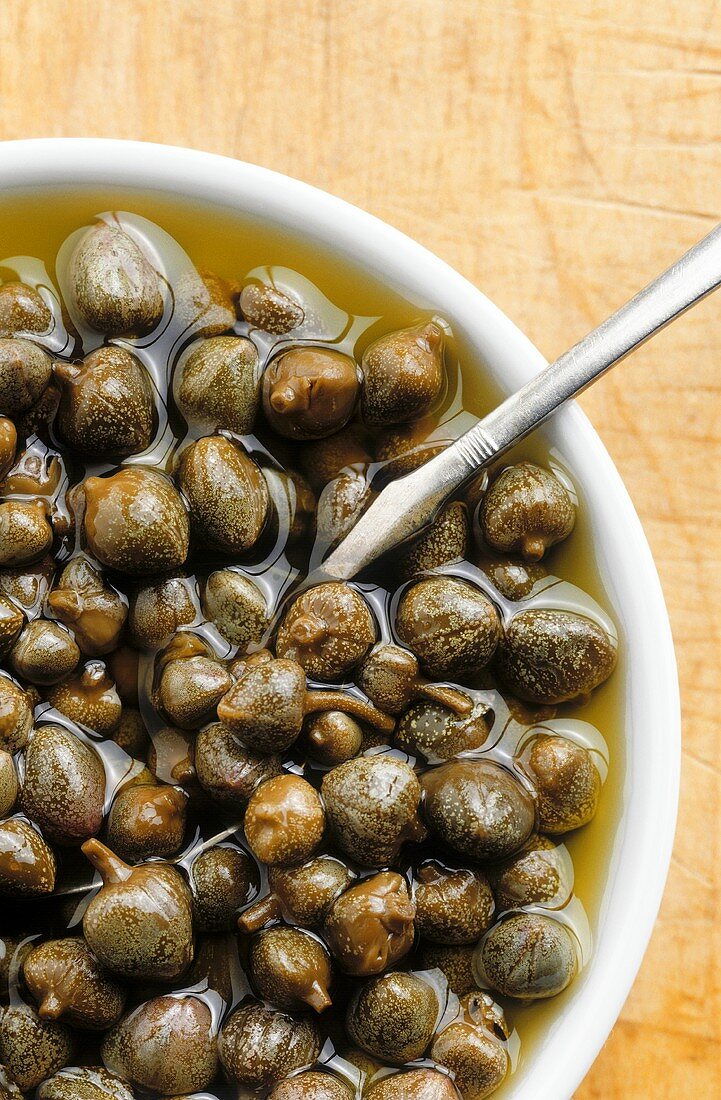 Pickled capers in a white bowl