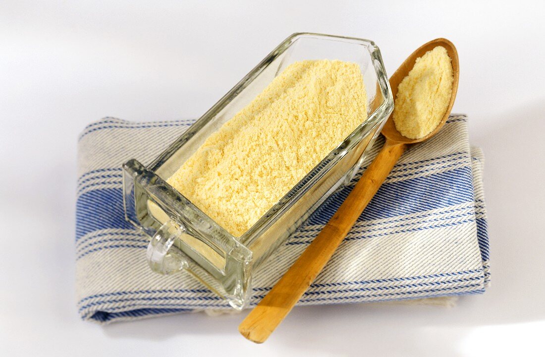 Polenta meal in glass container and on a spoon