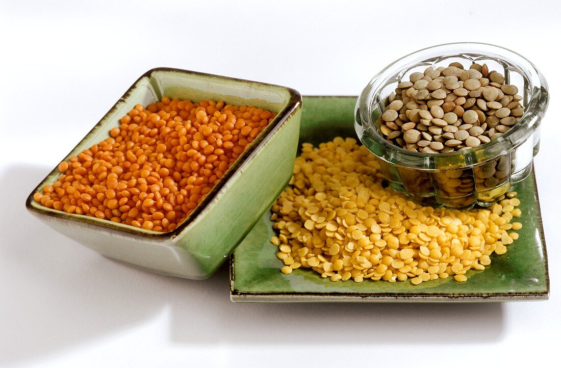 Red, brown and yellow lentils in bowls