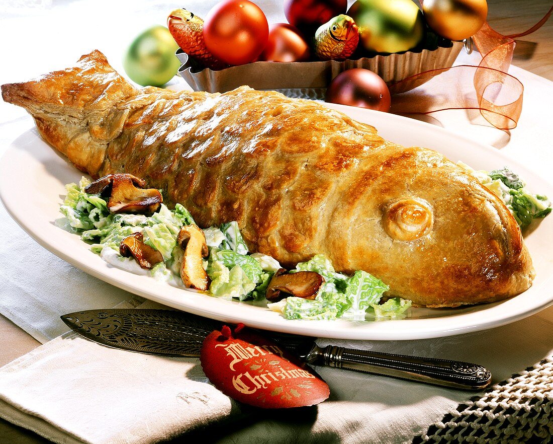 Fish in pastry casing on green salad with mushrooms