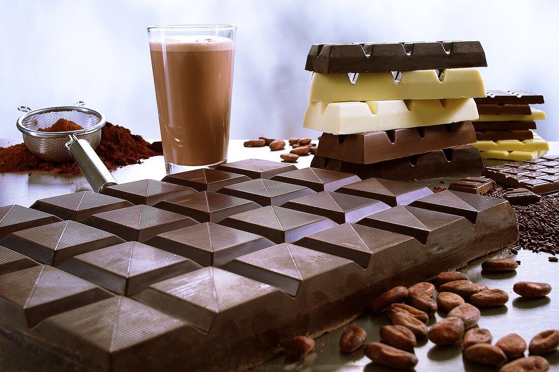 Schokoladentafel mit Kakao, Kakaopulver und Kakaobohnen