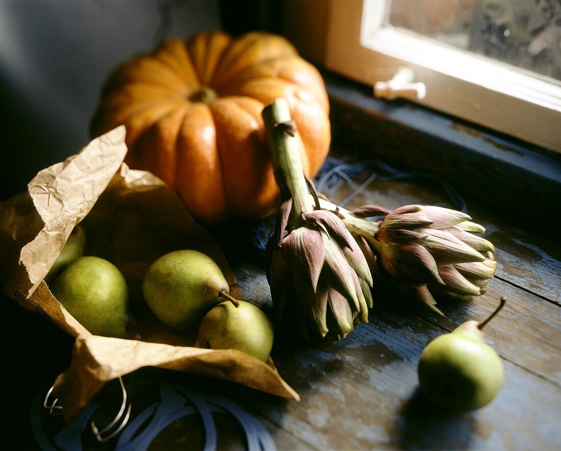 Pears, artichokes and pumpkin on window-sill