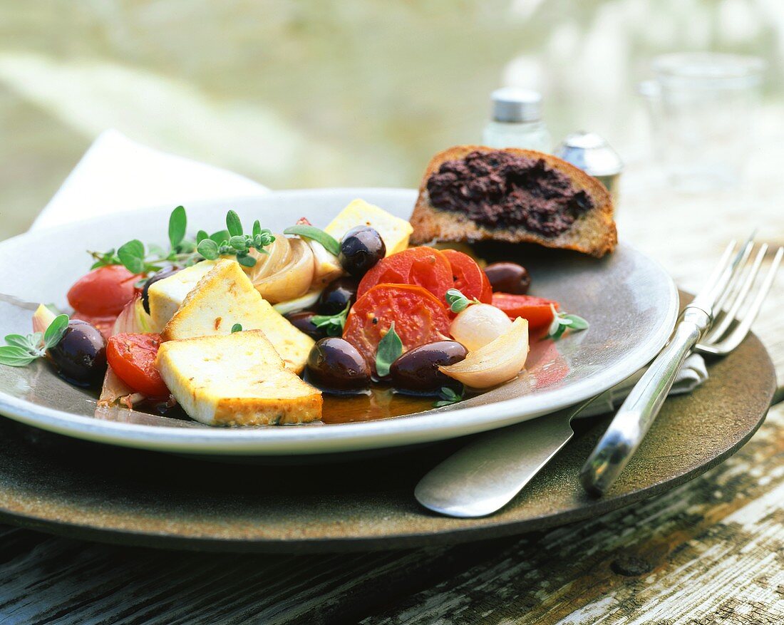 Geräucherter Tofu mit Tomaten und Oliven; Brot mit Tapenade