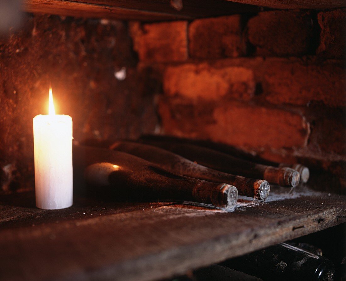 Candles beside wine bottles in Seppelt wine cellar, Victoria