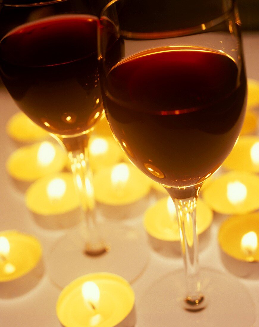 Zwei Gläser mit Portwein von brennenden Kerzen umgeben