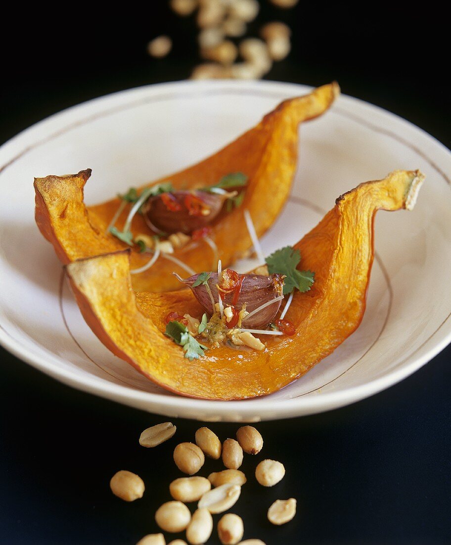 Baked pumpkin wedges with peanut and garlic dressing