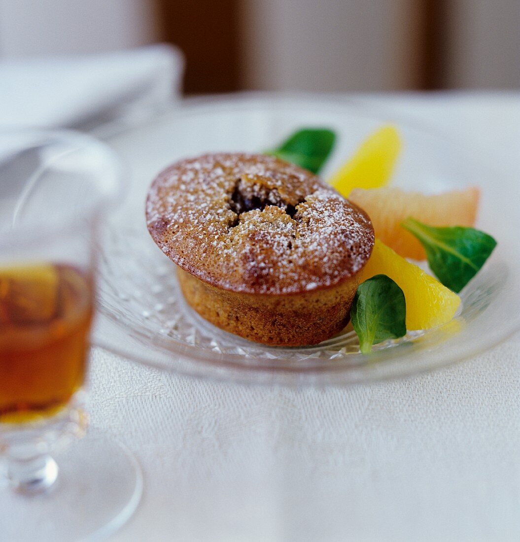 Sweet spiced bun with citrus fruit wedges on glass plate