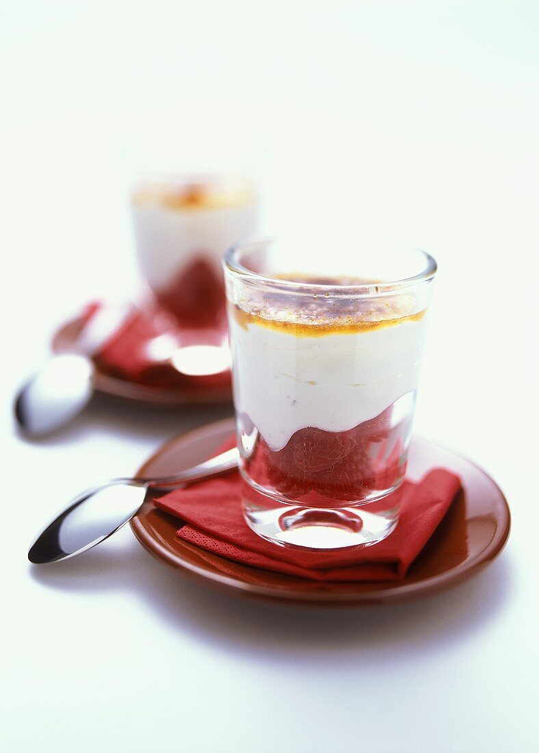 Heiße Himbeeren mit Sahnequark und Karamellhaube in Gläsern