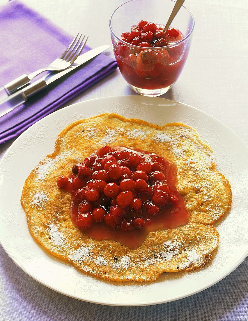 Walnut pancake with icing sugar and cranberry compote