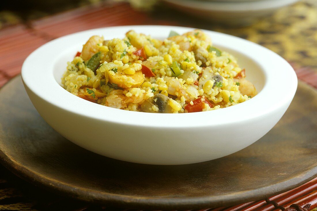 Couscous with shrimps and vegetables in a white bowl