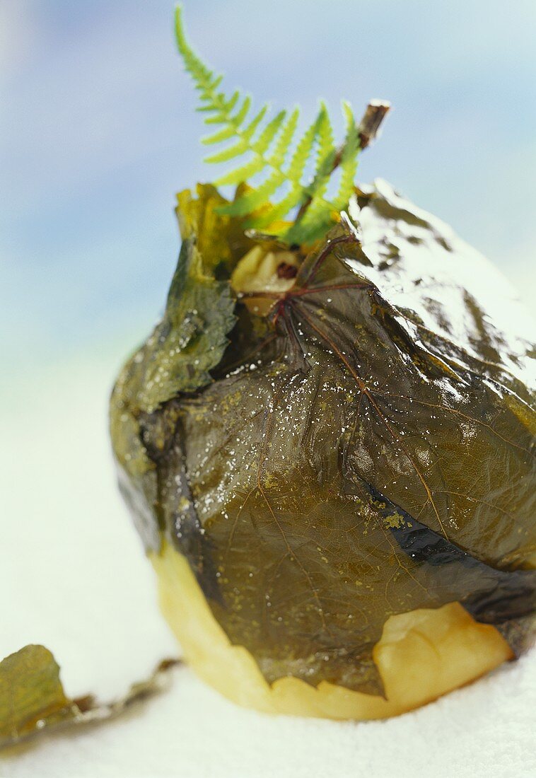 Poached apple in vine leaves