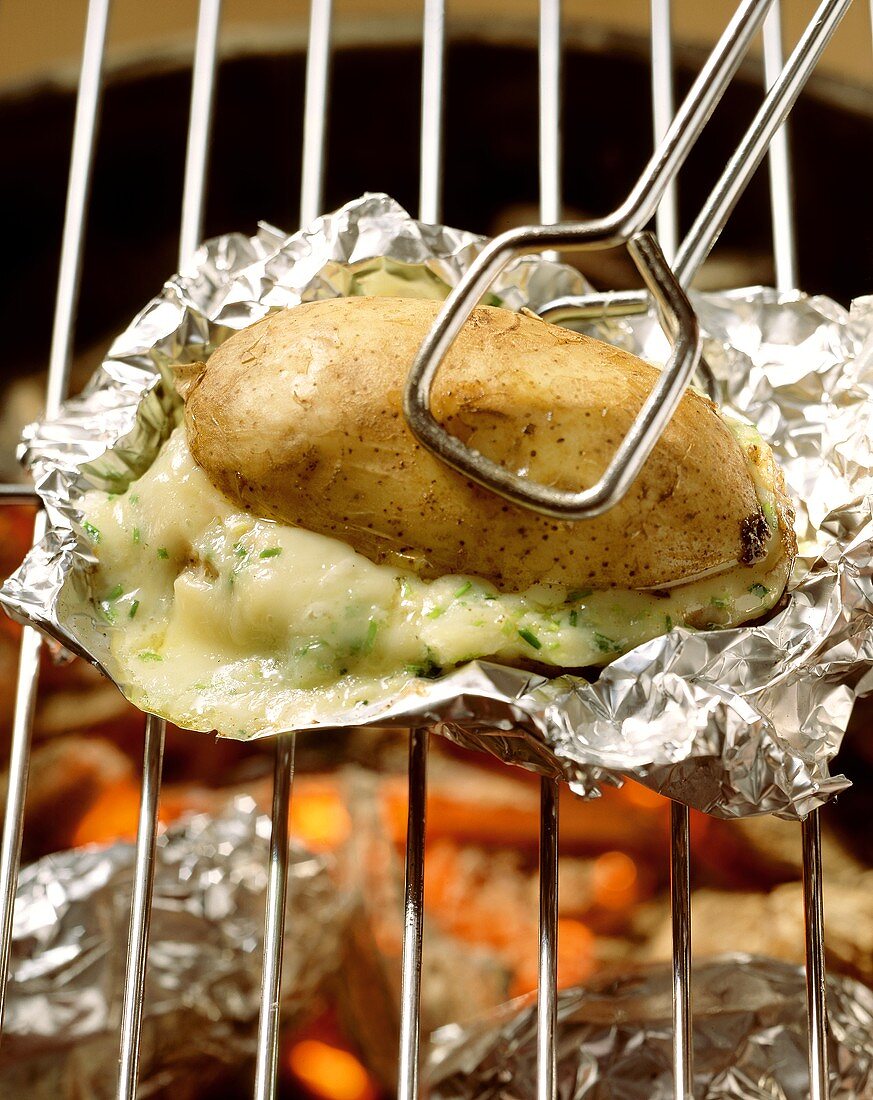 Baked potatoes with cheese filling on grill rack