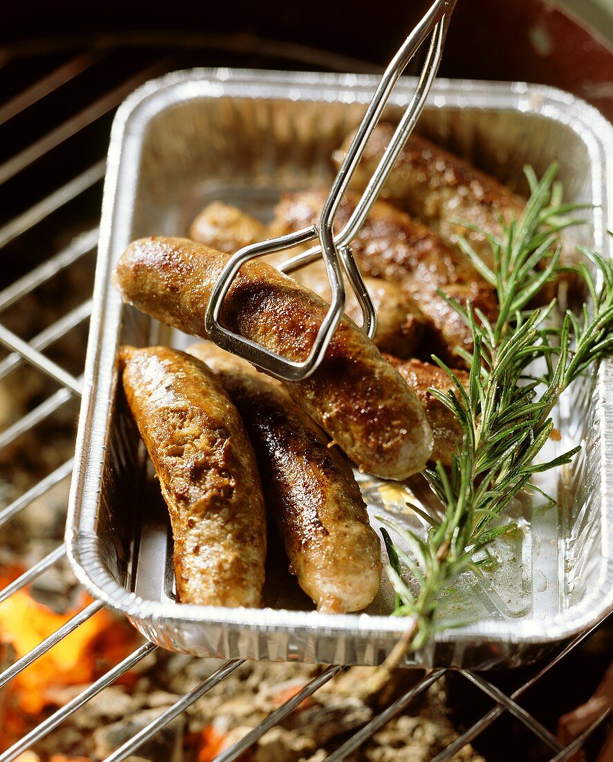 Home-made lamb sausages in aluminium dish