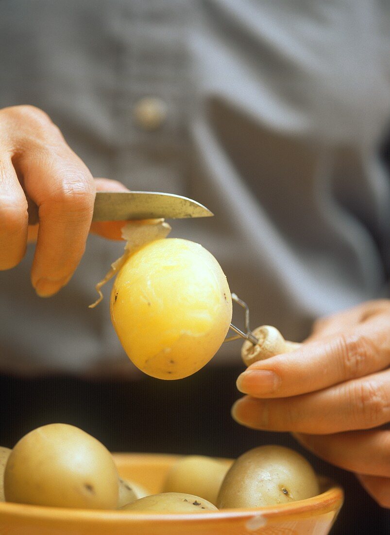 Kartoffeln mit Pellgabel und Messer pellen