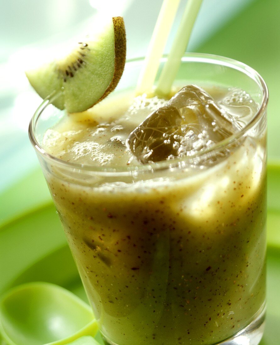 Kiwi fruit & banana drink with ice cubes and straws in glass