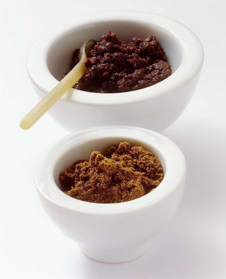 Garam masala as powder and paste in white bowls