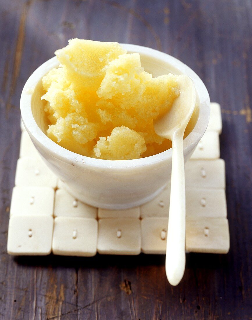 Ghee (clarified butter; India) in small bowl with white spoon