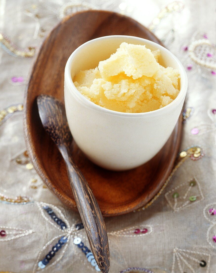 Ghee (geklärte Butter; Indien) im Schälchen mit Holzlöffel