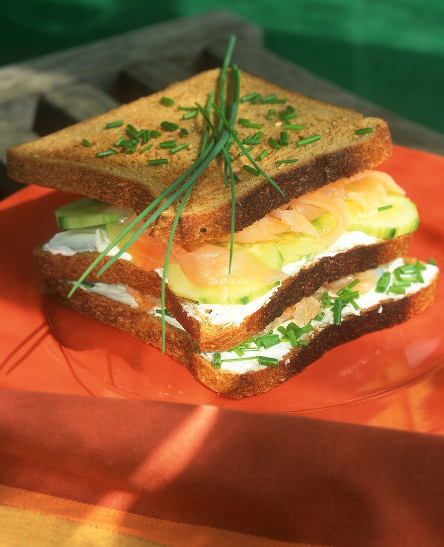 Vollkorntoast-Sandwich mit Firschkäse, Gurken und Lachs