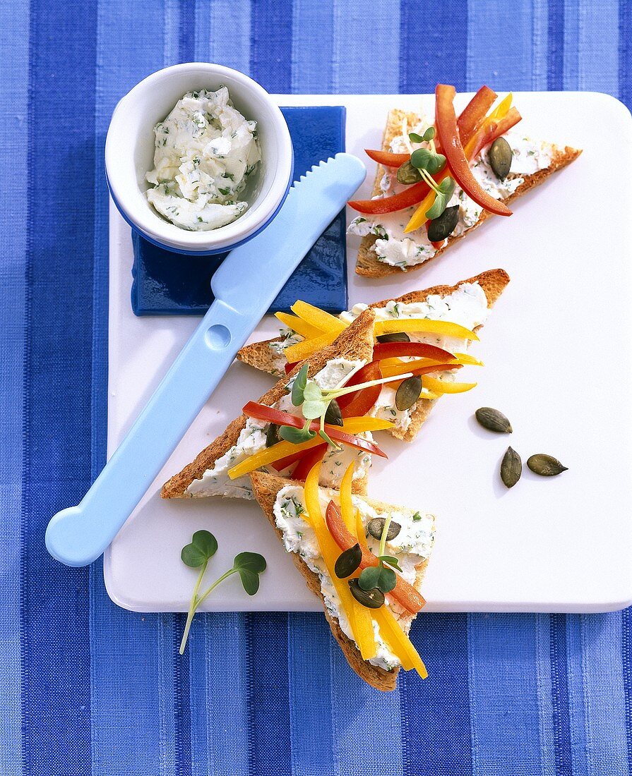 Wholemeal toast triangles topped with herb soft cheese & pepper