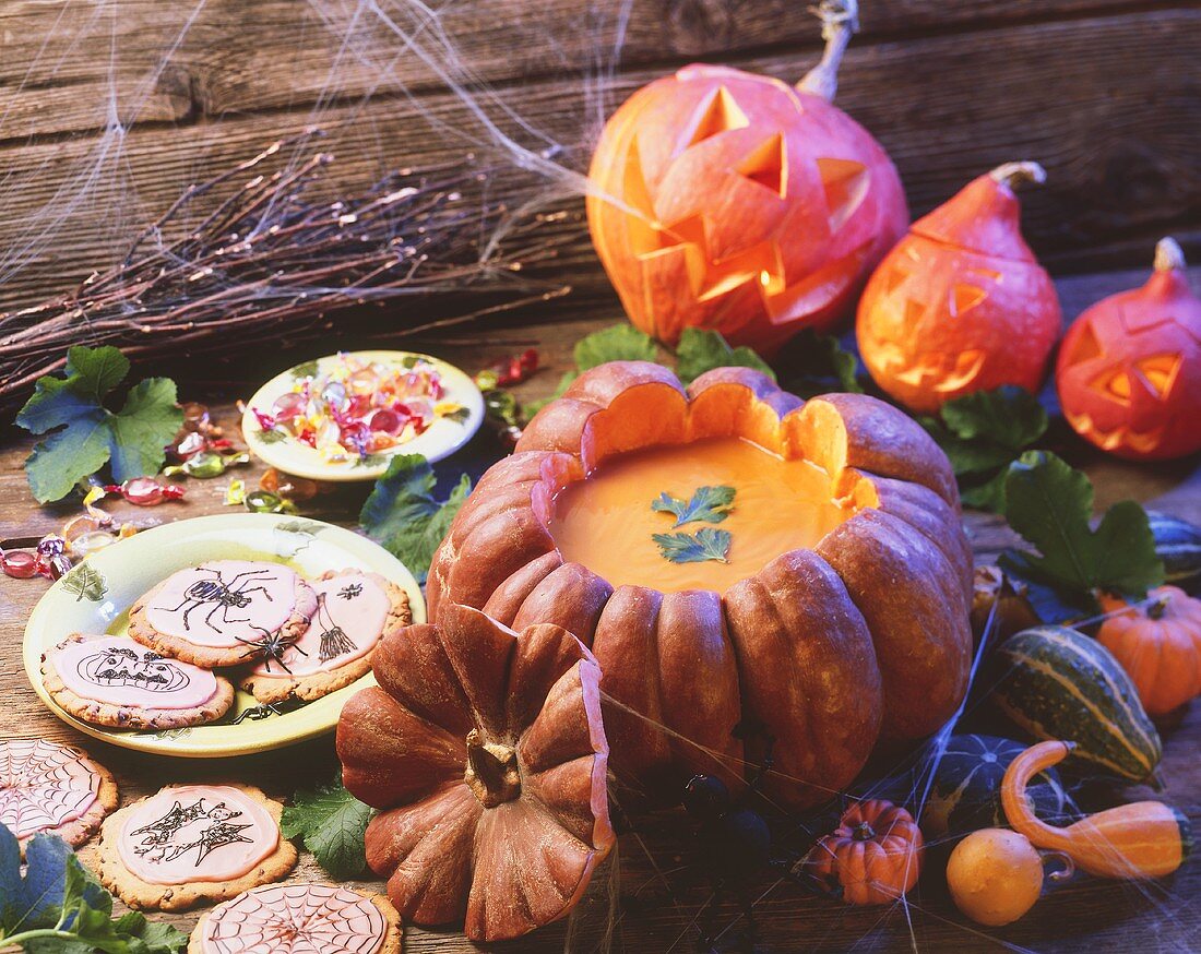 Halloween-Stillleben mit Kürbissuppe und Cookies